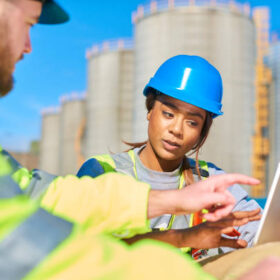 two site engineers discussing a project down at the dock yard